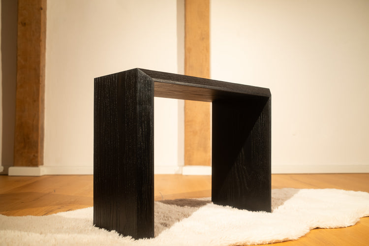 Gebeizter Hocker aus Esche, auf Teppich stehend, Frontalansicht